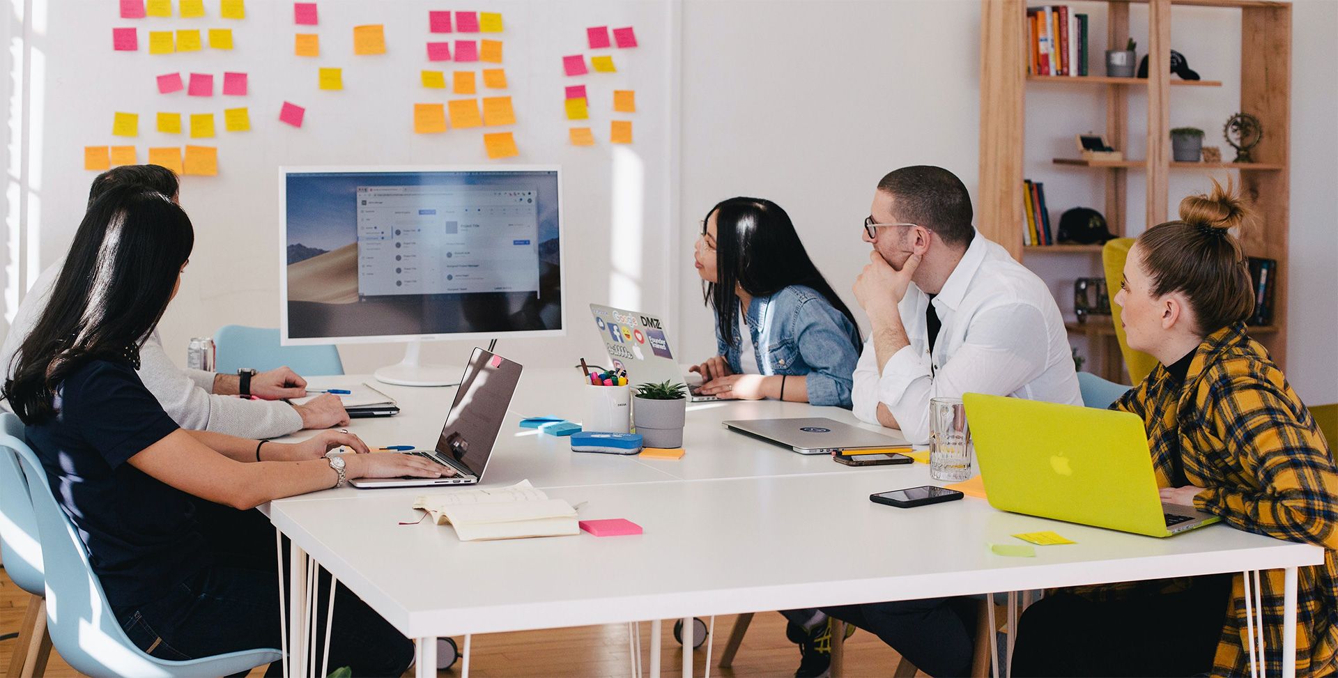 Team von Marketingexperten analysiert SEO-Strategien auf einem Monitor in einem hellen Büro.